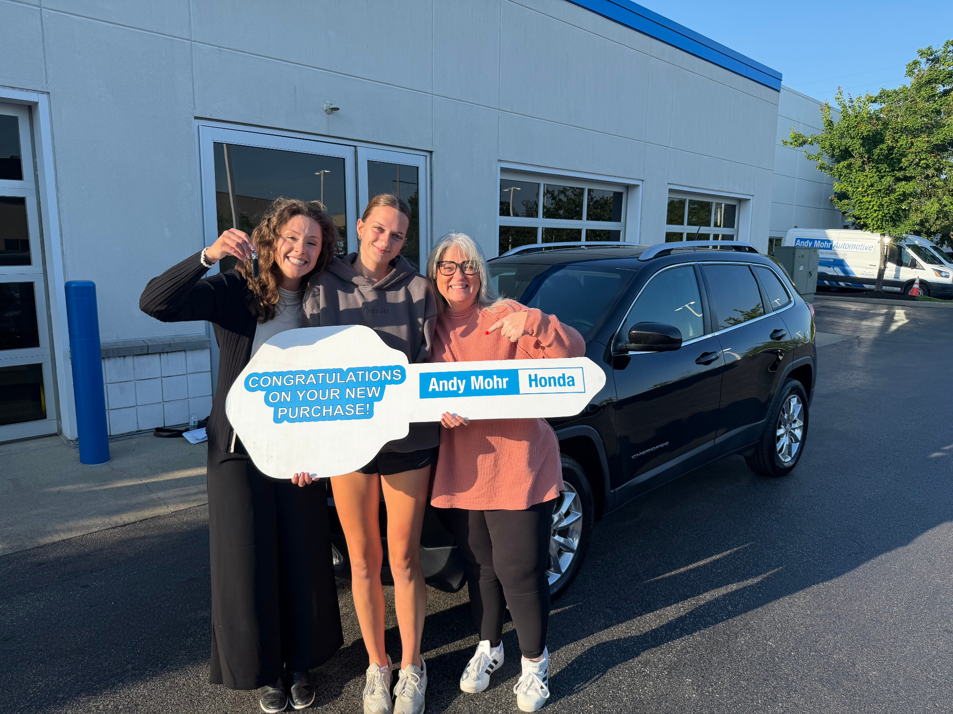 Lauryn celebrating with happy customers holding a giant key